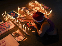 Protester lit candles spelling out '112' stand among pictures of detained political activists during a demonstration calling for the aboliti...