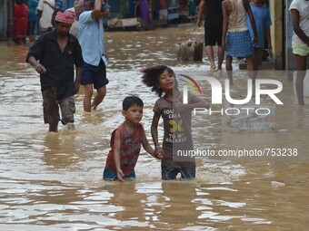 Two Indian kids wade through flooded street after heavy downpour in Dimapur, India north eastern state of Nagaland on Thursday, August 27, 2...