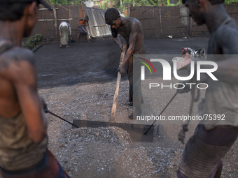 Bangladeshi factory workers work at a manual black oxide factory in Gazipur district on 6 April 2014. All the workers in this factory come f...