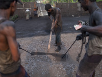Bangladeshi factory workers work at a manual black oxide factory in Gazipur district on 6 April 2014. All the workers in this factory come f...