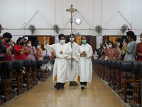 Altar boys carry the cross during Christmas Eve at a church in Bangkok, Thailand, 24 December 2021. (