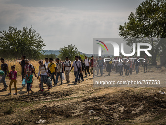 Migrants cross the border between Macedonia and Greece near the Macedonian town of Gevgelija on August 26, 2015. The EU is grappling with an...