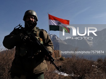 A Border Security Force (BSF) soldier stand alert near Indian National Flag (Tri-Color) at a forward post in Baramulla, Jammu and Kashmir, I...