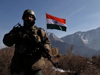 A Border Security Force (BSF) soldier stand alert near Indian National Flag (Tri-Color) at a forward post in Baramulla, Jammu and Kashmir, I...