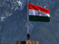 A Border Security Force (BSF) soldier stands alert near Indian National Flag (Tri-Color) at a forward post in Baramulla, Jammu and Kashmir,...