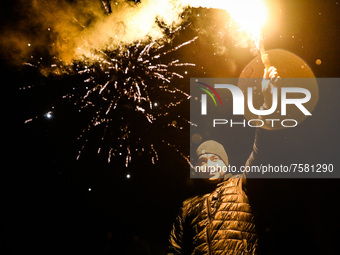 A man hold a flare while celebrating New Year at Krakus Mound in Krakow, Poland on 1st January 2022.
 (