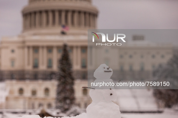 A tiny snowman sits in front of the US Capitol after an unexpected snowstorm dropped roughly 8 inches of snow on Washington, DC, effectively...