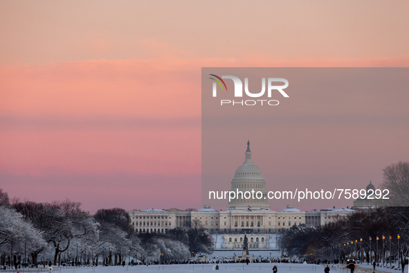 The sun sets over the US Capitol following an unexpected snowstorm that dumped roughly 8 inches of snow on Washington, DC. 