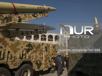 An Iranian cleric walks past Iranian solid-propelled road-mobile single-stage missile, Zolfaghar Basir (Top), and Dezful medium-range ballis...