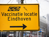 Road sign with directions towards the vaccination center location. Vaccination center in Eindhoven with 20 lanes and the capacity of 7500 va...