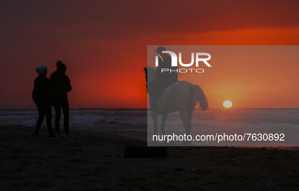 A Palestinian man rides his horse in front of Gaza beach during sunset, on January 13, 2022.  