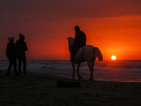 A Palestinian man rides his horse in front of Gaza beach during sunset, on January 13, 2022.  (