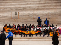 A Capitol Police officer stands guard with an assault rifle against faith Leaders and hunger strikers sitting on the steps of the Senate cha...