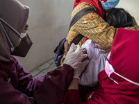 School child receive the COVID-19 vaccine in South Tangerang, Indonesia, on January 26, 2022 amid the COVID-19 pandemic. (