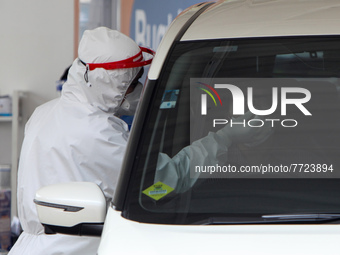A Medical worker conduct a COVID-19 test at a drive-thru COVID-19 testing site in Bogor, West Java, Indonesia on February 4, 2022, as Indone...
