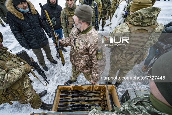 Volunteer of the 112th Territorial Defense Brigade of Kiev distributes rifles during a military exercise for civilians in the outskirts of t...