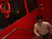 A waiter climbs a stair inside the double-decker dining bus restaurant, decorated with heart-shaped balloons ahead of Valentine's Day celebr...