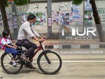 Father taking his child to school on a bicycle in Dhaka, Bangladesh on 27th March, 2022. (