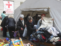 Ukrainian refugees who fled the war look at the clothes as they receive assistance at the city humanitarian volunteer center for helping ref...