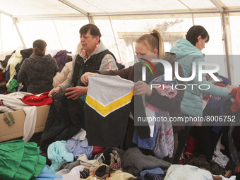 Ukrainian refugees who fled the war look at the clothes as they receive assistance at the city humanitarian volunteer center for helping ref...