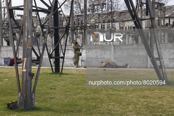 Ukrainian serviceman stands near a body of civilian in the recaptured by the Ukrainian army Bucha city near Kyiv, Ukraine, 04 April 2022. 