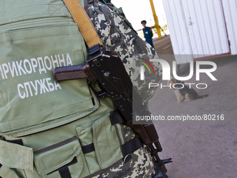 Ukrainian border guard with a gun stays at the BCP Customs Control Zone on the border between Ukraine and Moldova (