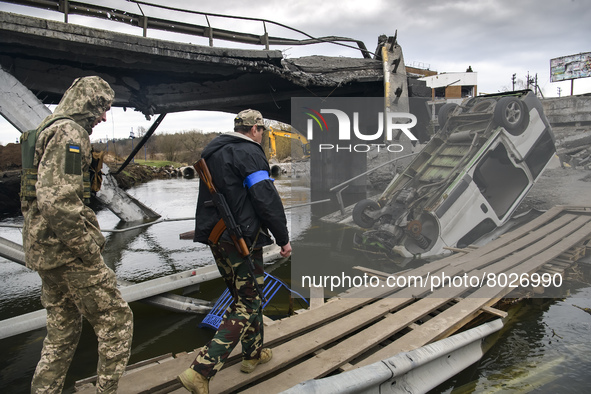Ukrainian servicemen cross the Irpin river near a destroyed bridge outside the recaptured city of Irpin, Ukraine, 06 April 2022 