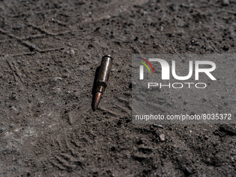 BUCHA, UKRAINE - APRIL 7, 2022 - A cartridge lies on the ground after the liberation of the city from Russian invaders, Bucha, Kyiv Region,...