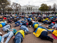 Protesters lie on the ground as they reenact the murder of 163 people in Bucha during a rally at the White House for Ukraine.  Hundreds of p...