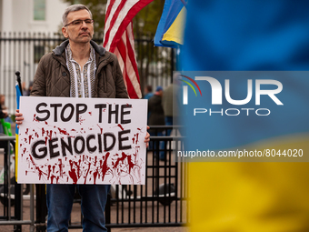 A man holds a sign demanding an end to what protesters consider genocide, during a rally at the White House for Ukraine.  Hundreds of people...