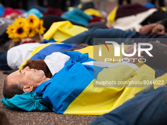 Protesters lie on the ground as they reenact the murder of 163 people in Bucha during a rally at the White House for Ukraine.  Hundreds of p...