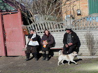 KYIV REGION, UKRAINE - APRIL 07, 2022 - Local residents sit on a bench in one of the settlements affected by the russian military invasion,...