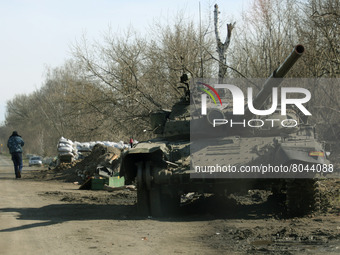 KYIV REGION, UKRAINE - APRIL 07, 2022 - A tank and a checkpoint on the side of the road as traces of the russian military invasion, Kyiv Reg...