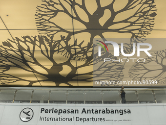 A man passing an International Departure wall at the newly completed budget airport KLIA2, in Sepang, Malaysia on April 12,2014.The KLIA2 wi...