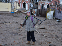 CHERNIHIV, UKRAINE - APRIL 11, 2022 - A boy with a kick scooter stands on a street covered by debris after the liberation of the city from R...