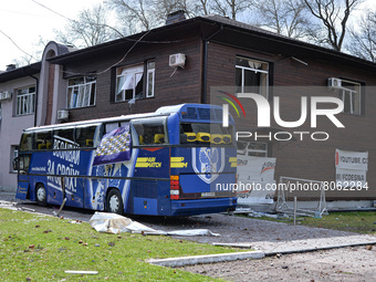 CHERNIHIV, UKRAINE - APRIL 11, 2022 - A damaged bus of FC Desna Chernihiv stays by a building with smashed windows near the Chernihiv Olympi...