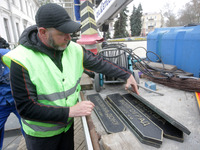 Ukrainian communal workers remove five plates with the names of Russian cities from the memorial sign with directions of Odesa's twin cities...