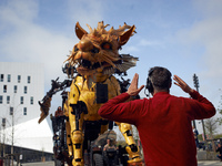 An operator gestures towards the people who drive Long-Ma. A robot, a mare-dragon called Long-Ma, created by Francois de la Rosiere and his...