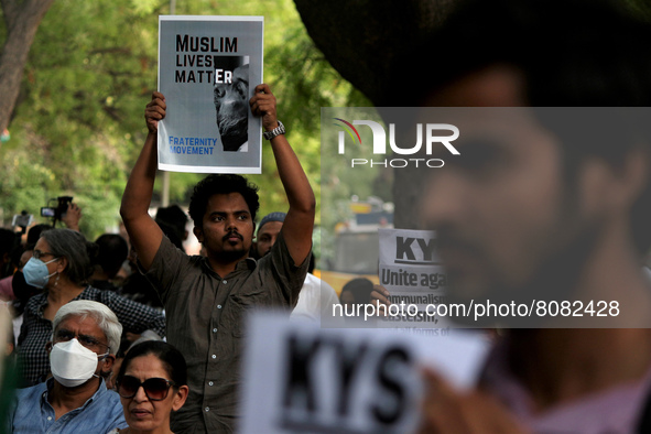 A protestor holds a placard during a demonstration against rise in hate crimes and anti-Muslim violence in New Delhi, India on April 16, 202...