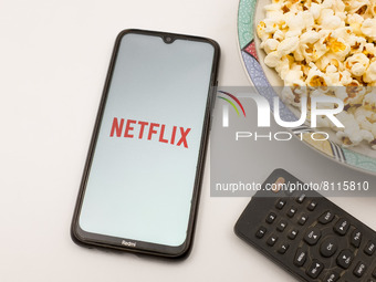 In this photo illustration Netflix logo seen displayed on a smartphone screen, a remote control and a bowl of popcorn in Chania, Crete Islan...