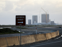 SpaceX's build site is seen in the distance behind a Historical Marker sign, a reminder that the area also a federal wildlife refuge and a C...
