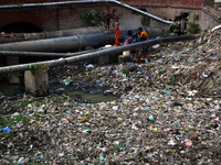 Indian people wash their clothes on a sevage water line that landed above a huge polluted canal, in Allahabad on October 2,2015.Thursday mar...