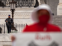 A Capitol Police officer armed with an assault rifle watches a protest by the Handmaids Army DC of the  Supreme Court's leaked preliminary d...