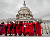 Demonstrators dressed as handmaids from The Handmaid's Tale, stand in front of the Capitol during a protest by the Handmaids Army DC of the...