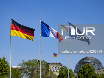 The German, French and European flags fly at the Chancellery in Berlin, Germany on May 9, 2022. (