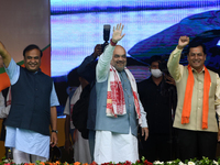 India's Home Minister Amit Shah along with Union Minister Sarbananda Sonowal and Assam Chief Minister Himanta Biswa Sarma waves towards supp...