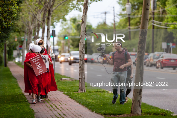 Two people with Breitbart film and harass demonstrators dressed as handmaids from the Handmaid's Tale.  Demonstrators were returning after r...