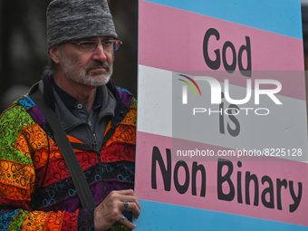 An activist holds a placard with words 'God is Non Ninary'.More than 100 local LGBTQ2S + supporters gathered Friday evening at the southeas...