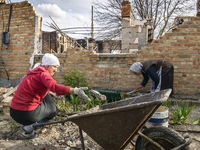 Local residents clean the remains their house destroyed during the Russian occupation of Zahaltsi village near Kyiv, Ukraine, ​May 13, 2022....