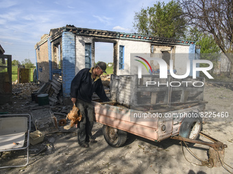 A local farmer Serhiy carries hens near his house destroyed during the Russian occupation of Zahaltsi village near Kyiv, Ukraine, ​May 13, 2...
